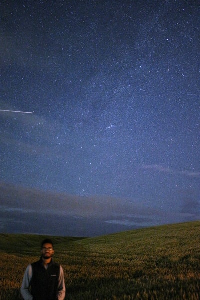 站在星空下草地上的人